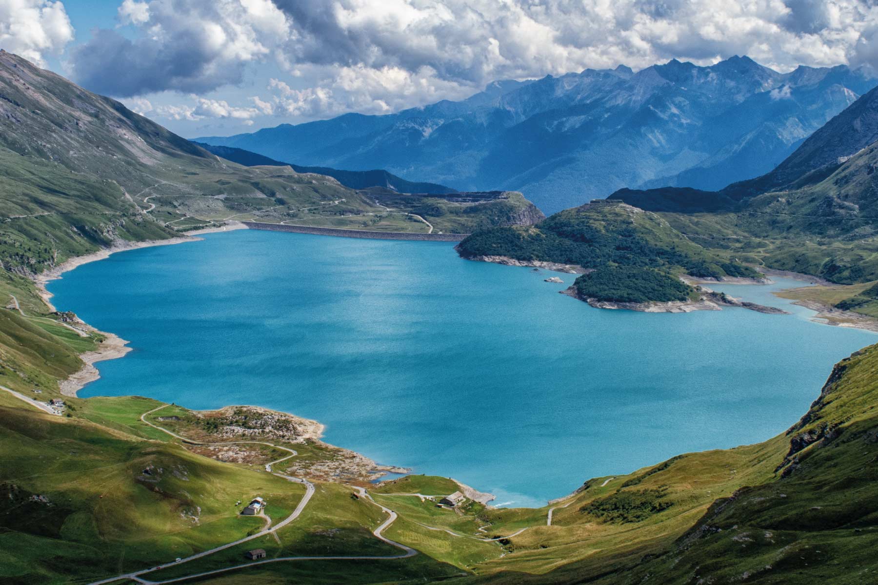 Panorama montano con un grande lago e cielo nuvoloso