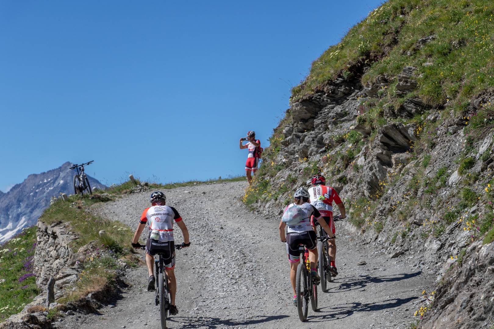 Ciclisti percorrono una strada sterrata di montagna