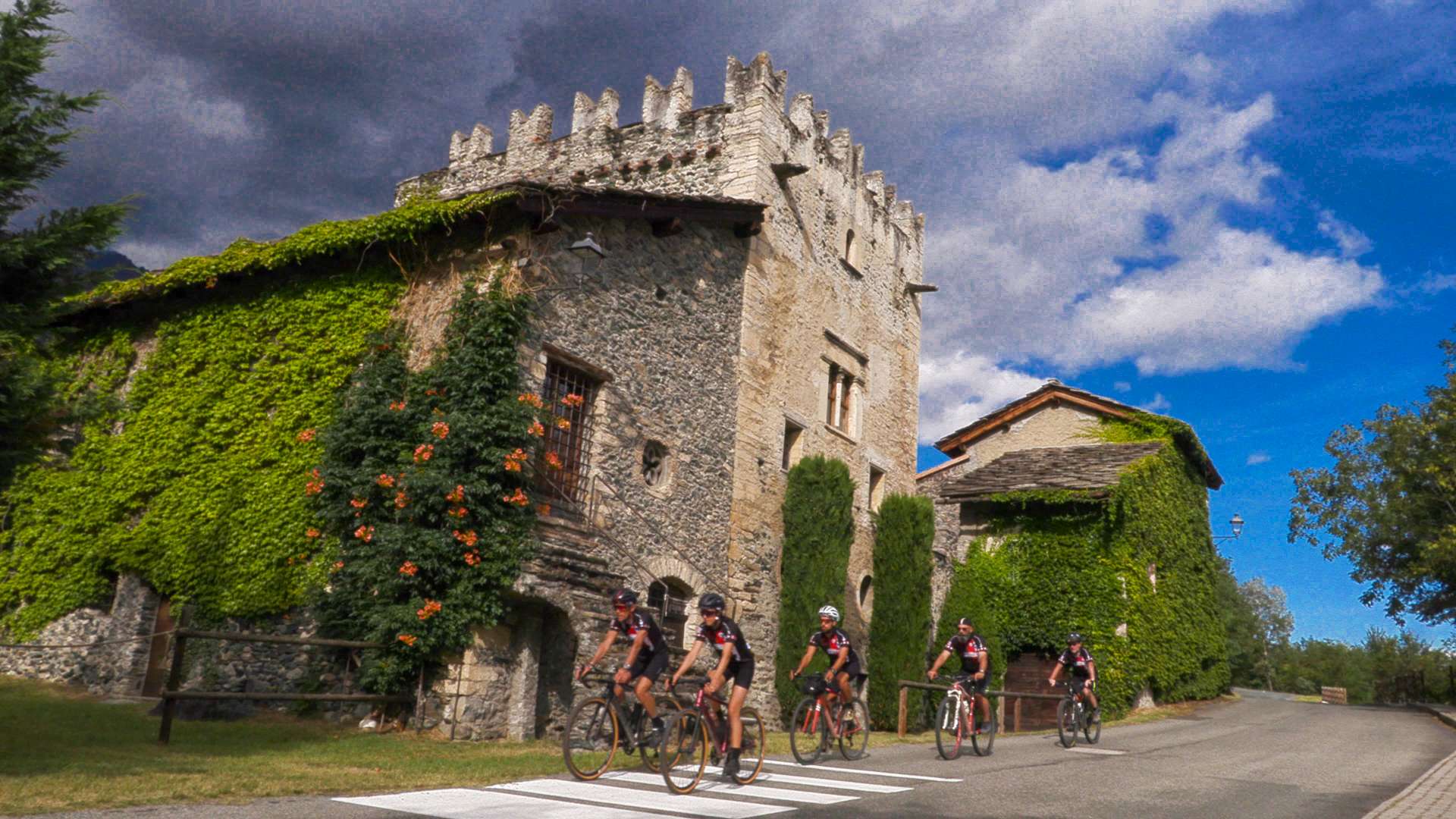 Ciclisti in corsa vicino ad antica casa