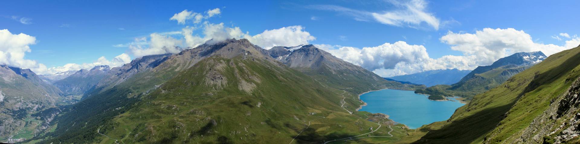 Paesaggio montano con distese verdi e un lago