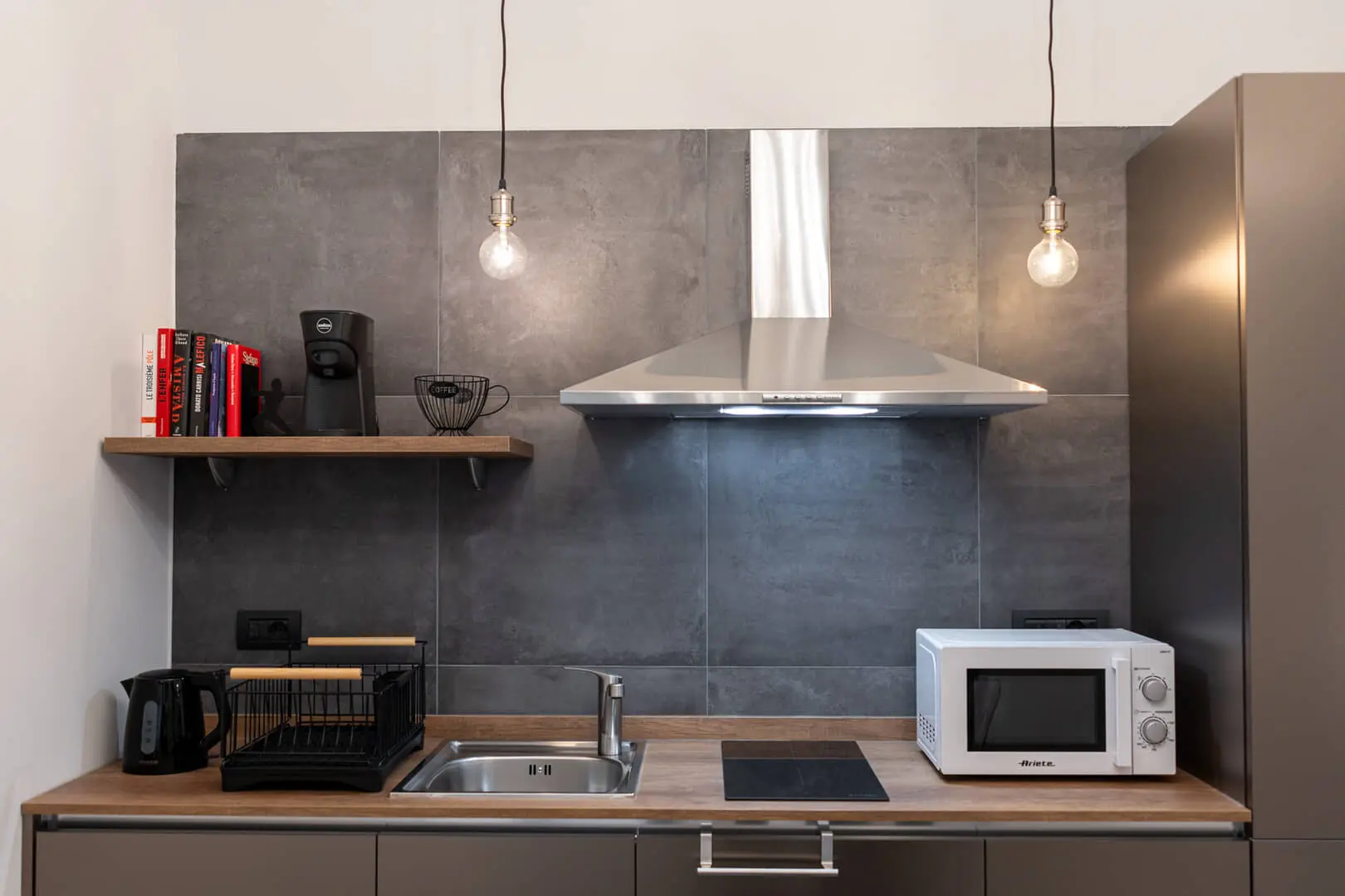 Cucina moderna con elettrodomestici e illuminazione minimalista.