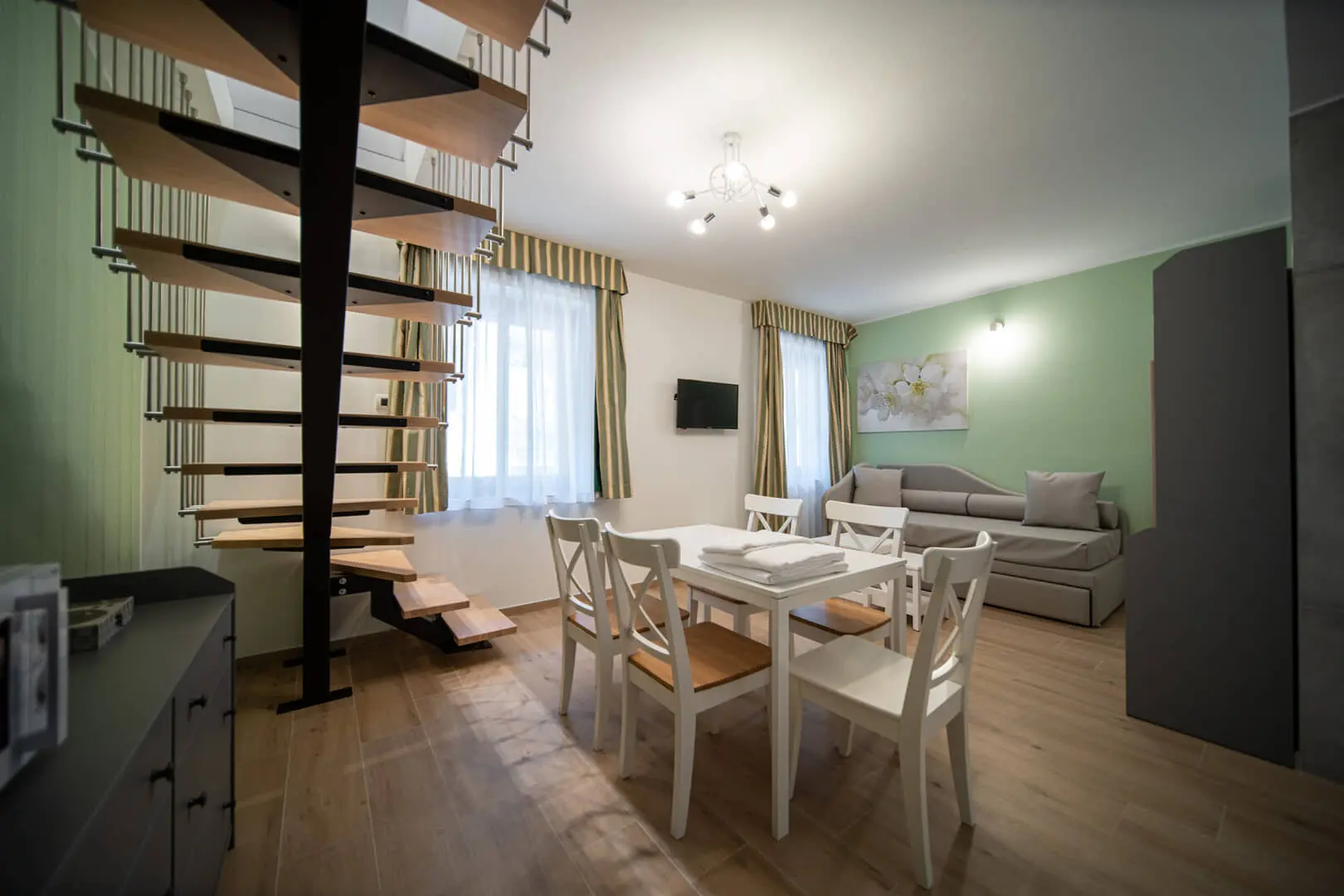 Interno moderno con scala a chiocciola e divano.
