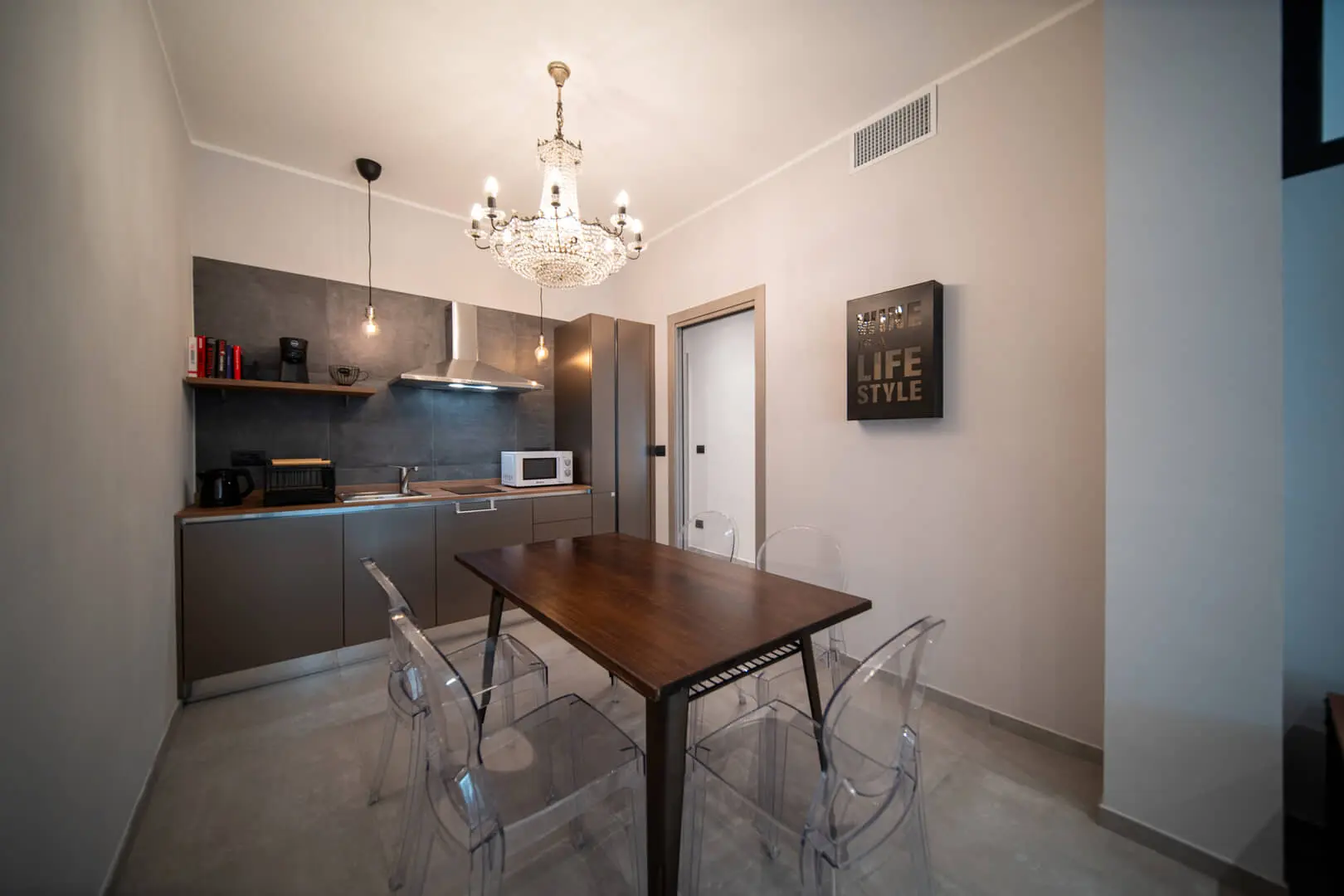 Cucina moderna con tavolo e lampadario elegante.