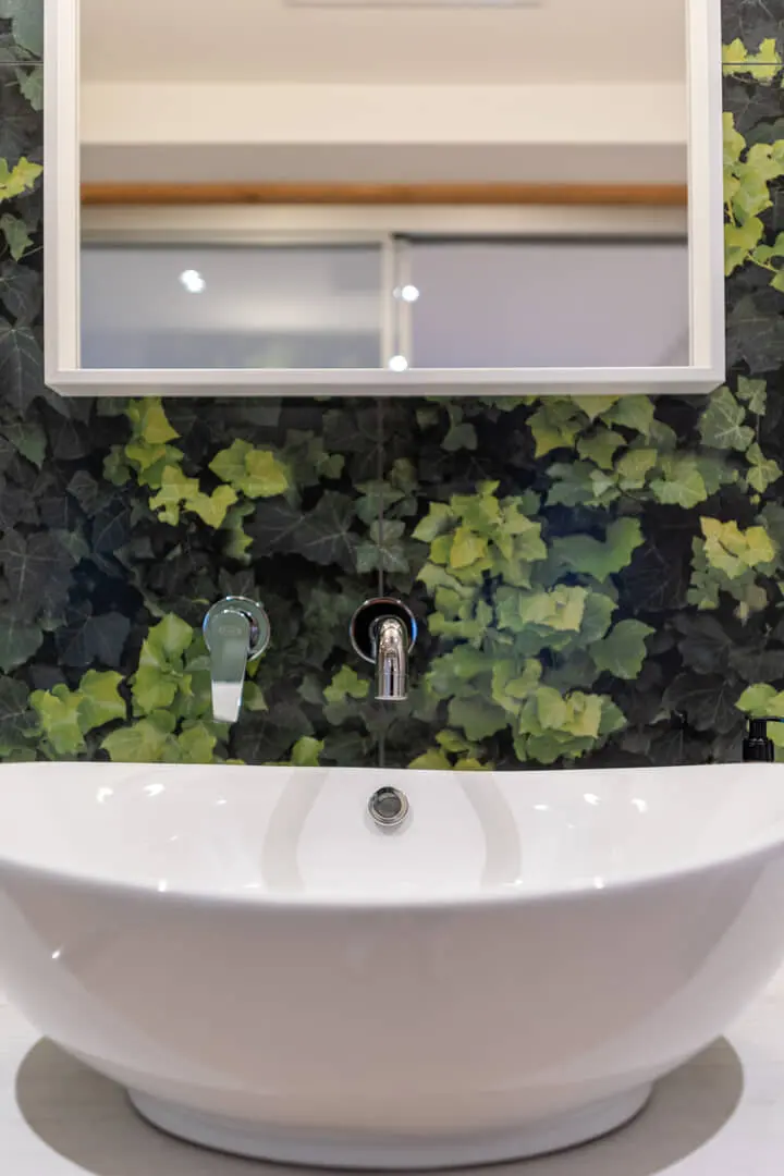 Lavabo moderno con fogliame verde.